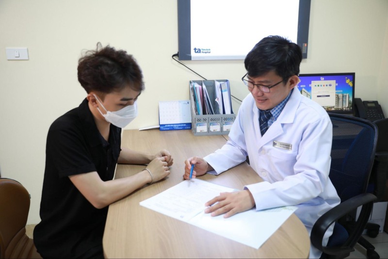 nam giới được tư vấn với bác sĩ trước khi tiêm vắc xin
