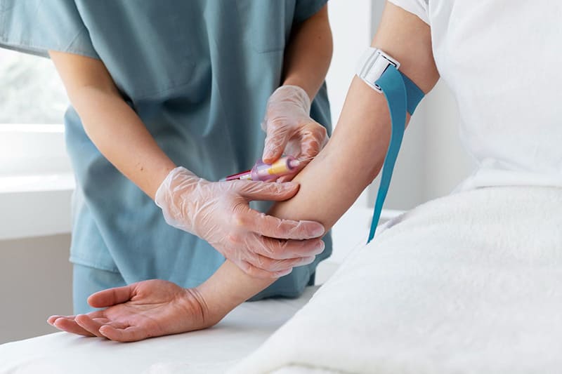 kỹ thuật viên sẽ đặt dây garo và tiến hành lấy máu
