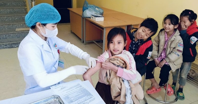 nhân viên y tế tiêm vắc xin cho trẻ em