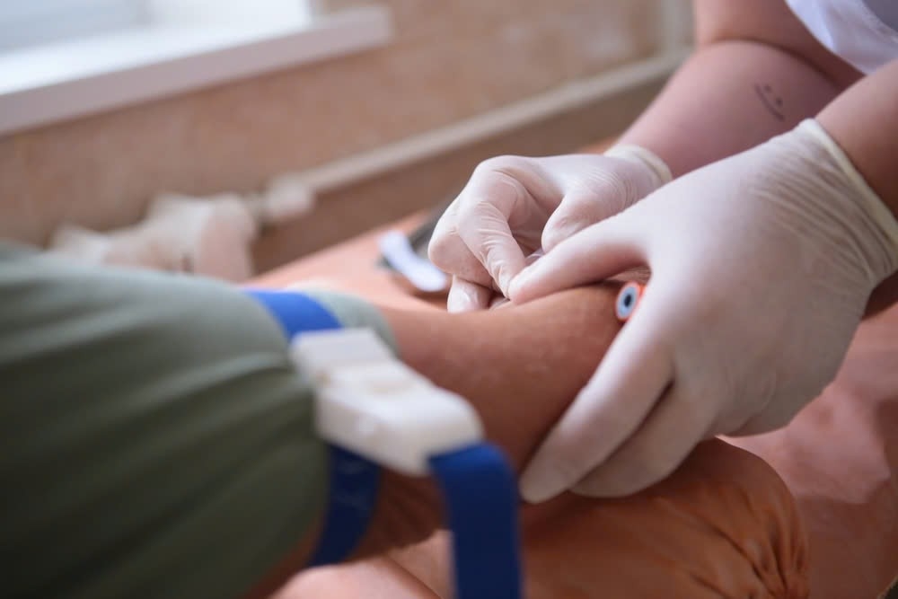 bác sĩ xét nghiệm máu bệnh nhân